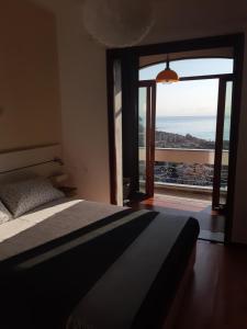 una camera con un letto e una grande finestra di Bressa de Ma affittacamere, room & breakfast a Pietra Ligure