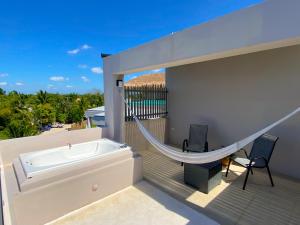 a balcony with a tub and a hammock at Maia Suites Cozumel in Cozumel