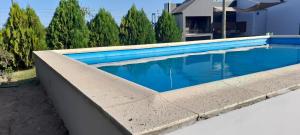 una piscina de agua azul frente a una casa en Hermosa Casa Quinta en Junin en Junín
