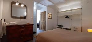 ein Bad mit einem Bett, einem Waschbecken und einem Spiegel in der Unterkunft Domaine Saint Bonnet in Puimoisson
