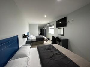 a hotel room with two beds and a television at Casa Picacho by Cobo´s in Aguascalientes