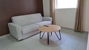 ein Wohnzimmer mit einem Sofa und einem Tisch in der Unterkunft Résidence Paradis in Petit-Bourg