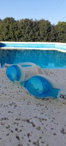 un par de gafas de sol azules sentadas junto a una piscina en Hermosa Casa Quinta en Junin en Junín