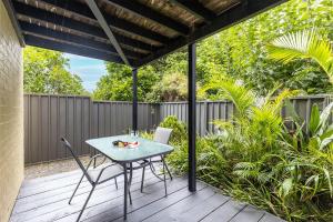 a patio with a table and chairs on a deck at Starfish at Anna Bay 4 Fishermans Bay Road in Anna Bay