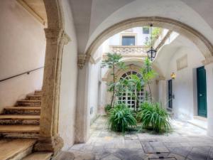 ein Torbogen, der zu einem Gebäude mit Pflanzen führt in der Unterkunft Miro B&B in Lecce