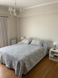1 dormitorio con cama y lámpara de araña en SWEET HOME MAR DEL PLATA en Mar del Plata