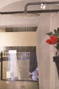 a shower head and a window with a curtain at Palazzo Trigona Suites in Noto