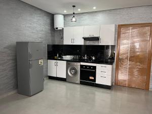 una cocina con nevera y lavadora en Appartement familial Soleil et Mer à 150m de la Plage de Mehdia, en Plage de Mehdia