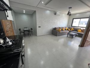 a large living room with a couch and a table at Appartement familial Soleil et Mer à 150m de la Plage de Mehdia in Plage de Mehdia