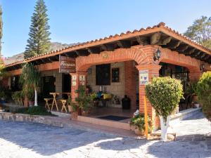 a brick building with an arch in a yard at Hotel Quinta Mirador Zacualli in Bernal