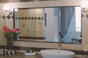 a bathroom with a sink and a mirror at Palazzo Trigona Suites in Noto