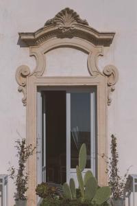 a window with an ornate frame on a building at Palazzo Trigona Suites in Noto