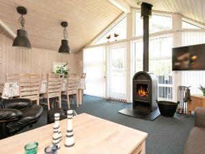 a living room with a fireplace and a table at Holiday Home Sølvgranvej in Marielyst