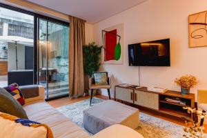 - un salon avec un canapé et une télévision dans l'établissement Design Antas Home, à Porto