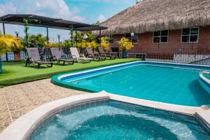 Una piscina con sillas y un edificio. en Ecovilla Cali, en Cali