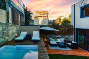 um pátio com uma piscina e cadeiras ao lado de um edifício em Design Antas Home em Porto