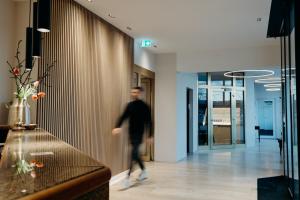 a man walking down a hallway in a building at Hotel Crystal in Saarbrücken
