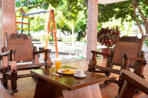 a table and chairs with a plate of food on it at Hotel Campestre Villa Ocha in Valledupar