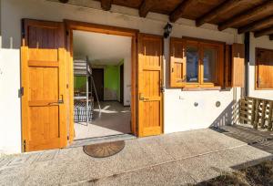 une porte d'entrée ouverte d'une maison avec des portes en bois dans l'établissement Casa Smile con vista mozzafiato, à Lizzola Alta