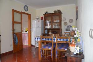 a kitchen with a table and chairs and a refrigerator at Mosteiros Gem - Excepcional Views and Stunning Sunsets in Ponta Delgada
