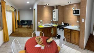 cocina con mesa roja y sillas en una habitación en Departamento Center en San Fernando del Valle de Catamarca