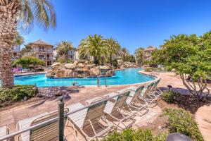a resort pool with chairs and a water slide at Villages of Crystal Beach Family Tides in Destin