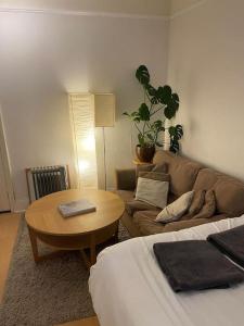 een woonkamer met een bank en een tafel bij Cosy Studio West Hampstead in Londen