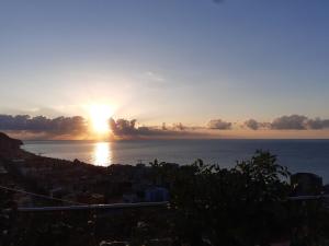 un tramonto sull'oceano con il sole nel cielo di Bressa de Ma affittacamere, room & breakfast a Pietra Ligure