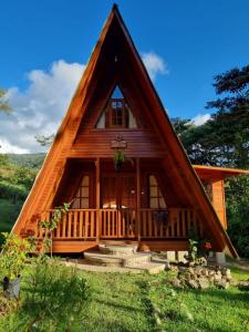 Cabaña con techo de paja y porche en Oxablues Home Lodge, en Oxapampa