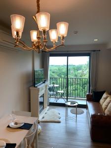 a living room with a couch and a chandelier at Rain Chaam Huahin by Joe in Phetchaburi
