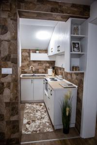 una cocina con armarios blancos y fregadero en Smile en Pirot