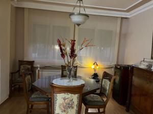 Granada, ciudad encantada في Cájar: طاولة غرفة الطعام مع إناء من الزهور عليها