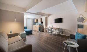 ein Wohnzimmer mit Couch und Tisch in der Unterkunft elaya hotel oberhausen in Oberhausen
