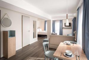 a room with a table and chairs and a bedroom at elaya hotel oberhausen, Trademark by Wyndham in Oberhausen
