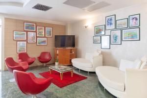 sala de estar con sofá blanco y sillas rojas en Best Western Hotel Imperiale, en Nova Siri Marina