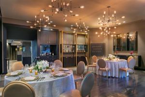 a dining room with tables and chairs and chandeliers at The Royal Sonesta Chicago River North in Chicago