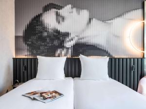 two beds in a room with a painting on the wall at Tribe Amsterdam City in Amsterdam