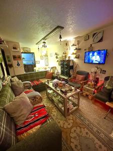 Petra Heritage House في وادي موسى: غرفة معيشة مع أريكة وتلفزيون