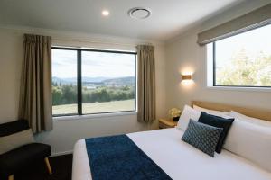 een hotelkamer met een bed en een groot raam bij Wanaka Top 10 Holiday Park in Wanaka