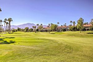 een golfbaan met palmbomen en een groen bij Golf Resort Condo about 6 Mi to Empire Polo Club! in La Quinta