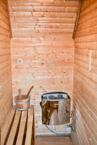 Spacious Primrose Lodge for 6 with Hot Tub at a Spa Resort في Chudleigh: داخل ساونا خشبية مع دلو