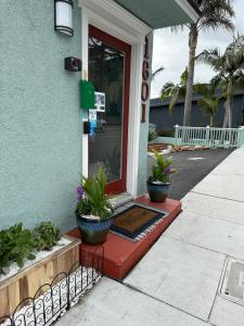 a front door of a building with potted plants at The Palomar Inn in Pismo Beach