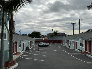 un estacionamiento con un coche estacionado frente a las casas en The Palomar Inn, en Pismo Beach