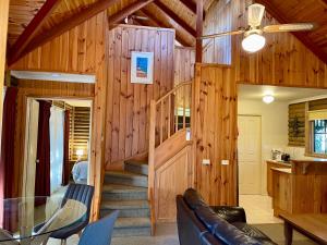 uma sala de estar com paredes de madeira e uma escada em espiral em Ti-Tree Village em Ocean Grove