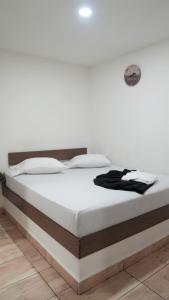 łóżko w pokoju z białą ścianą w obiekcie Hotel Salamanca Resort w mieście Itagüí