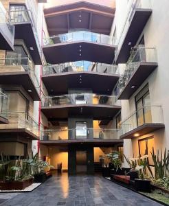 ein großes Gebäude mit Balkonen und Pflanzen darin in der Unterkunft Departamento nuevo en el corazón de la Condesa in Mexiko-Stadt