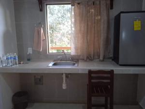 a kitchen counter with a sink and a window at Ecohotel Shalom in Valladolid