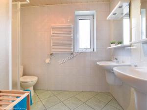 baño con lavabo y aseo y ventana en Willa Bumerang & SKI en Karpacz