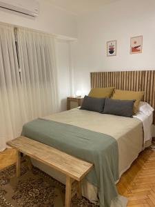 Un dormitorio con una cama grande con un banco. en Julia's House en Buenos Aires
