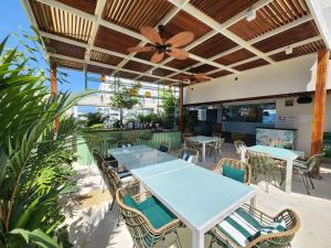 a patio with tables and chairs and a ceiling fan at Holiday Inn Express - Cartagena Bocagrande by IHG in Cartagena de Indias +135 photos